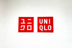 Logos of Uniqlo in English and Japanese on a white wall