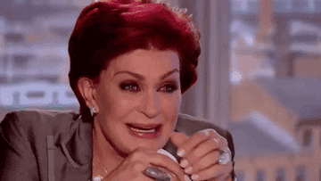 Sharon Osbourne is laughing with her hands close to her face