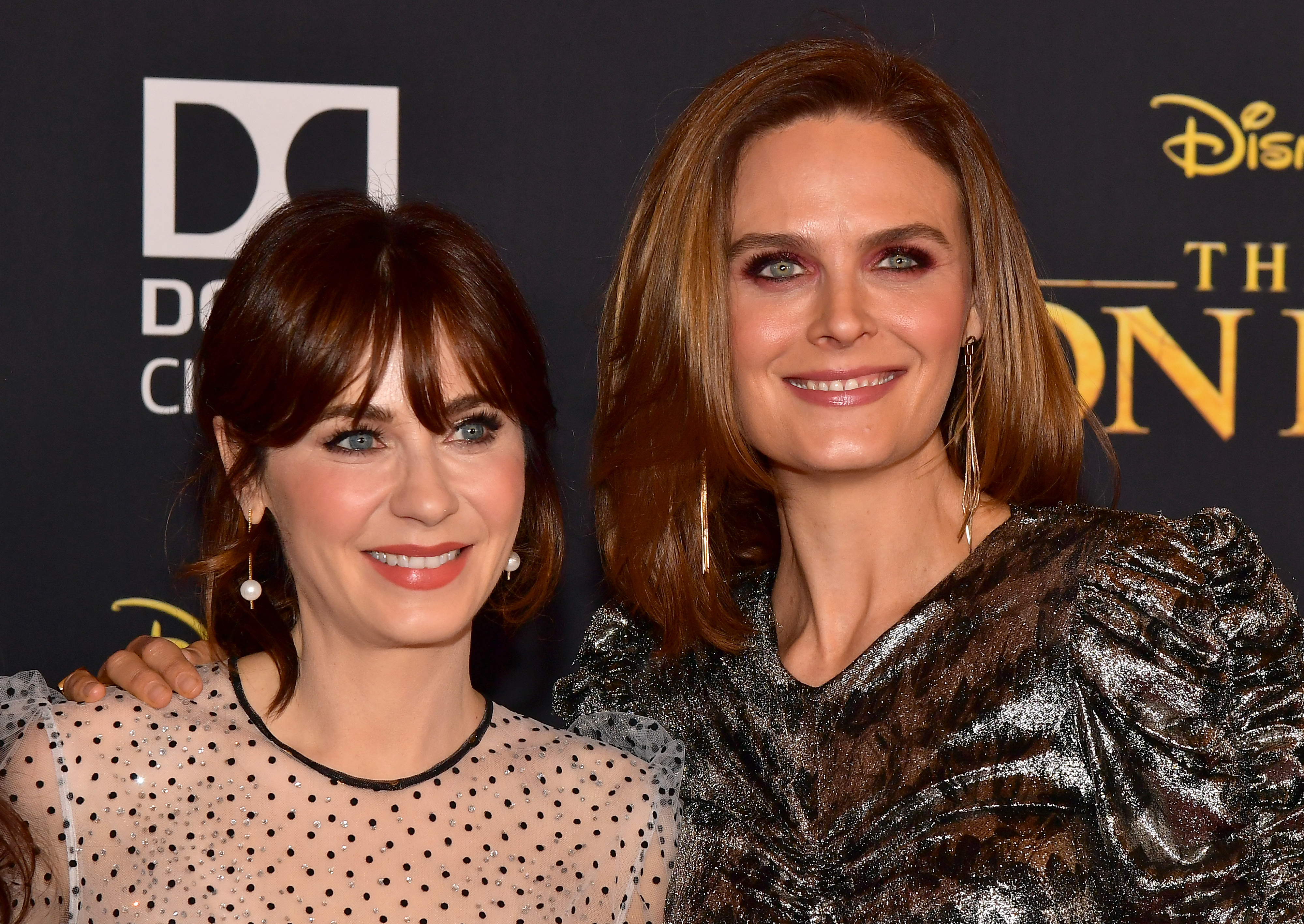 Zooey Deschanel and Emily Deschanel smiling for photographers at an event