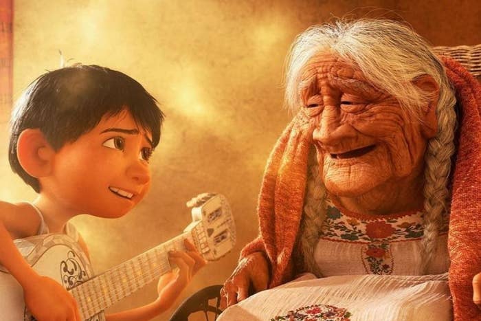 Animated character Miguel from Coco with his guitar beside elderly character Mama Coco, both smiling warmly