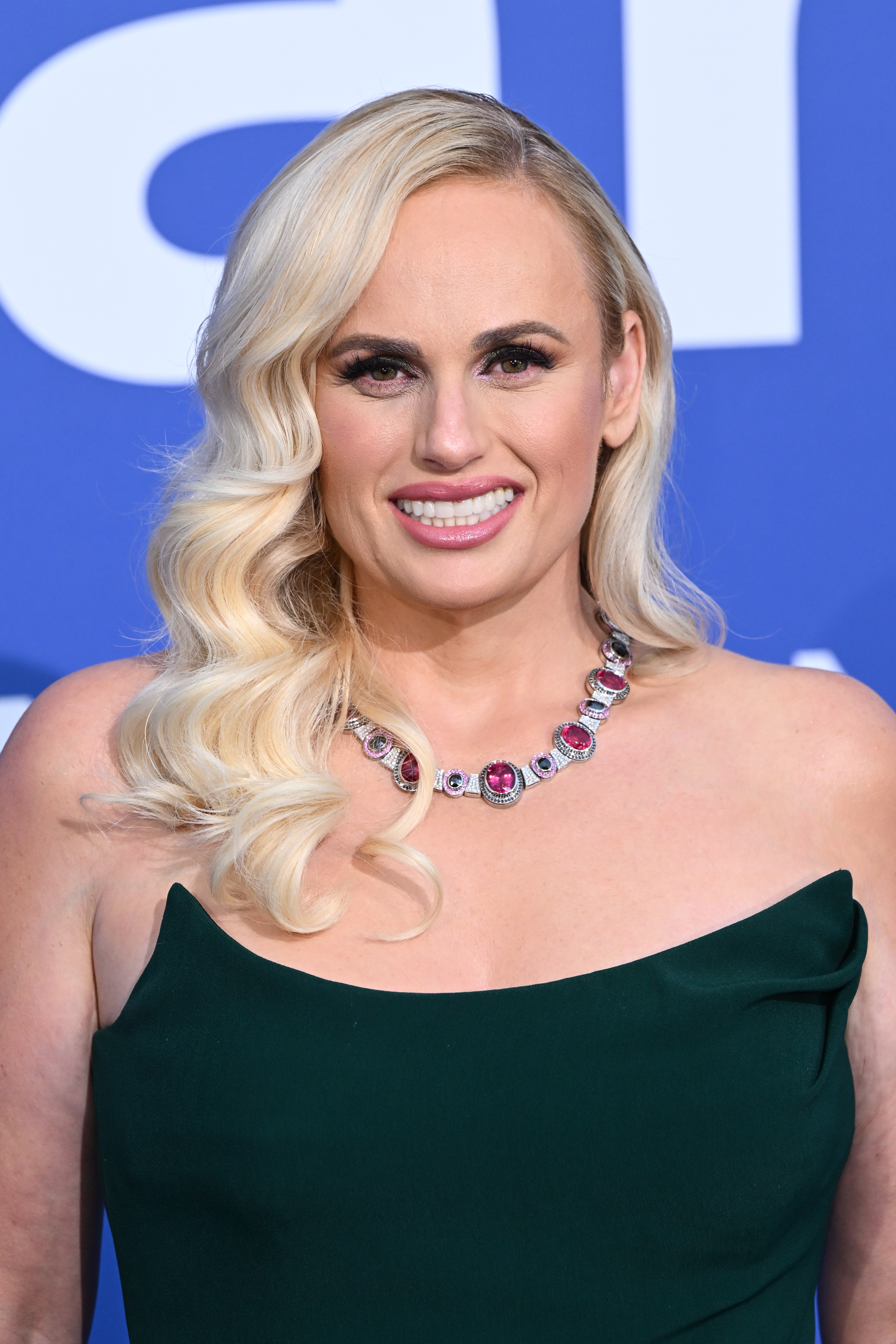 Rebel Wilson in a strapless dress with a multi-colored stone necklace on the red carpet