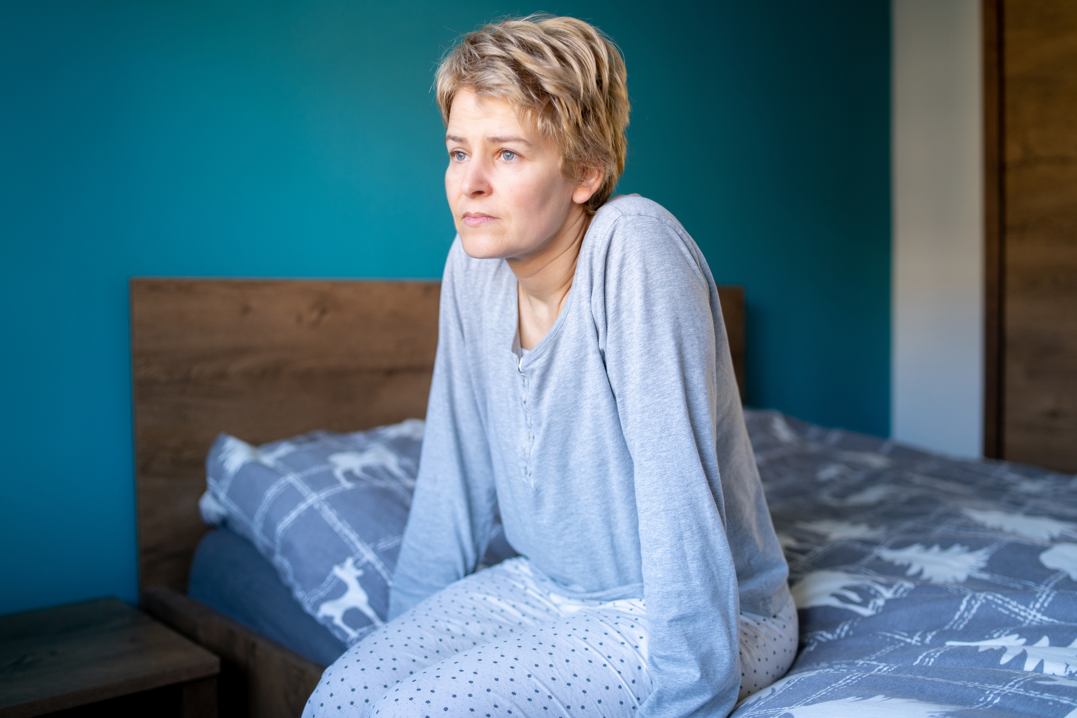 Person sitting on a bed looking contemplative, possibly reflecting on relationship issues