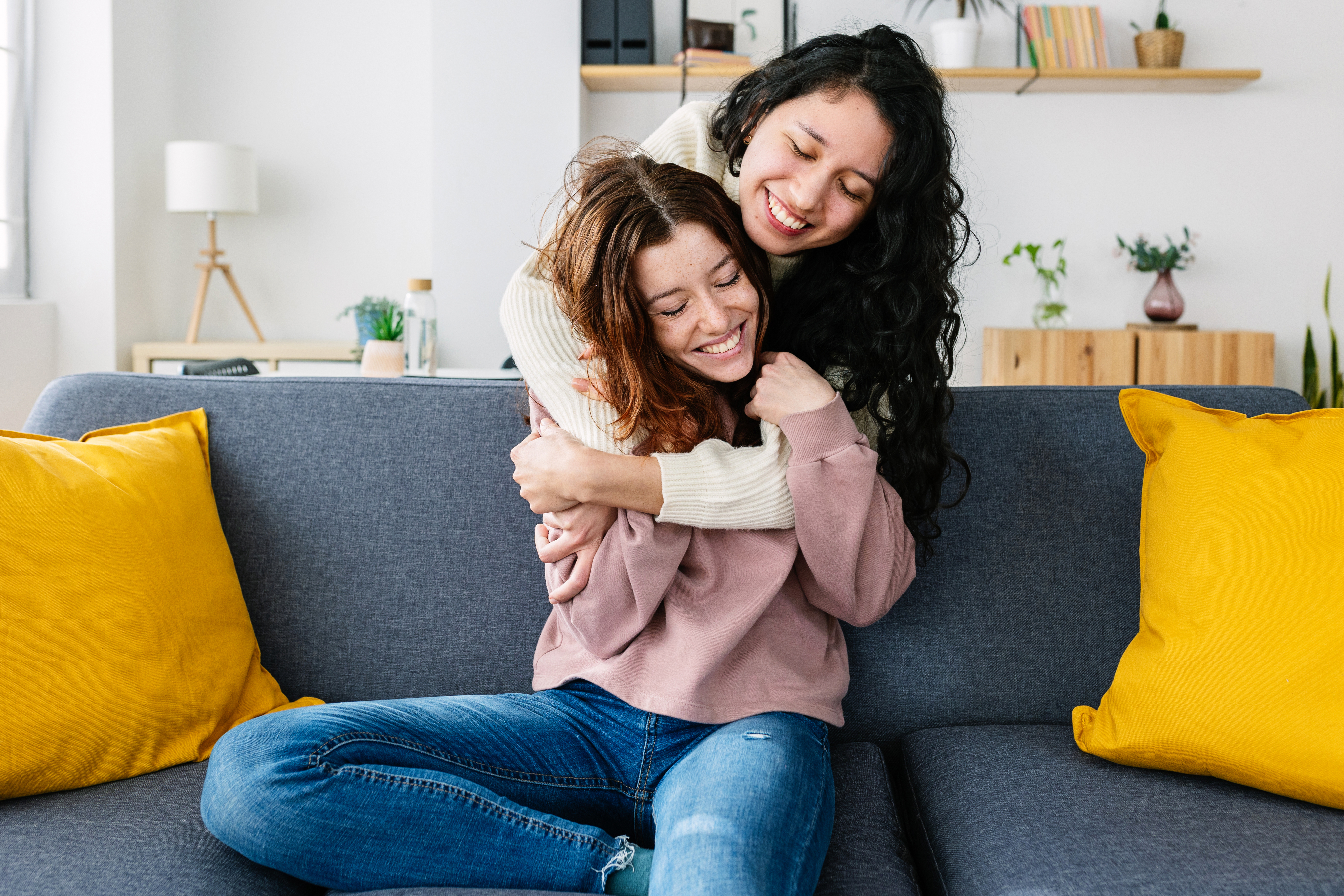 Two women embracing each other affectionately on a couch
