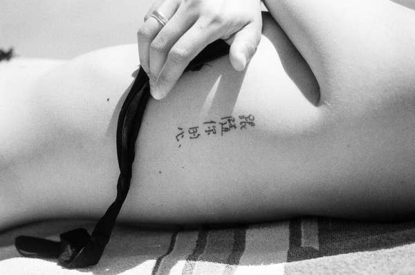 Person&#x27;s ribs with a tattoo featuring Chinese characters