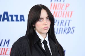 Person in a black suit with layered necklaces at the Independent Spirit Awards