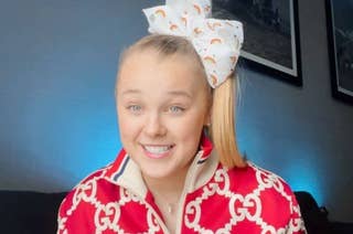 Person smiling wearing a bow and patterned outfit