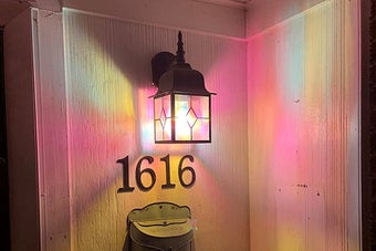 reviewer image of the stained glass lightbulb in a sconce on a porch