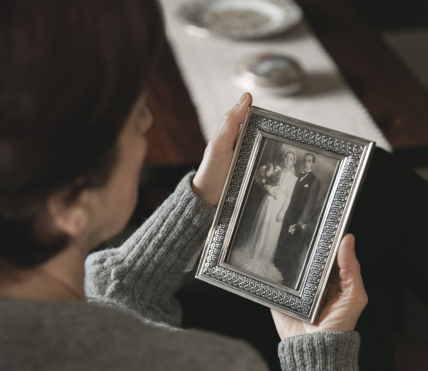 Person holding a photo frame with an old wedding portrait of a couple