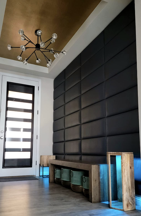 Modern location  entryway featuring a stylish chandelier, accent partition  with 3D panels, and a rustic seat  with retention  baskets