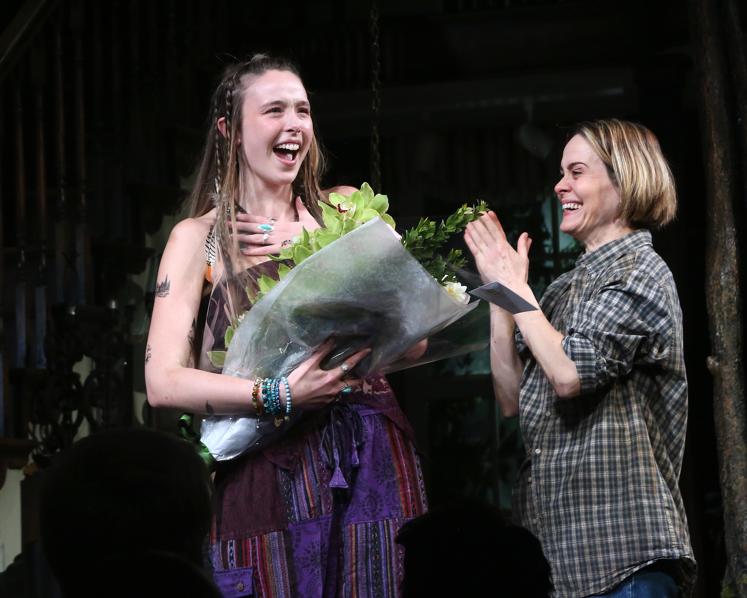 Ella receiving flowers as Sarah claps at the conclusion of the play