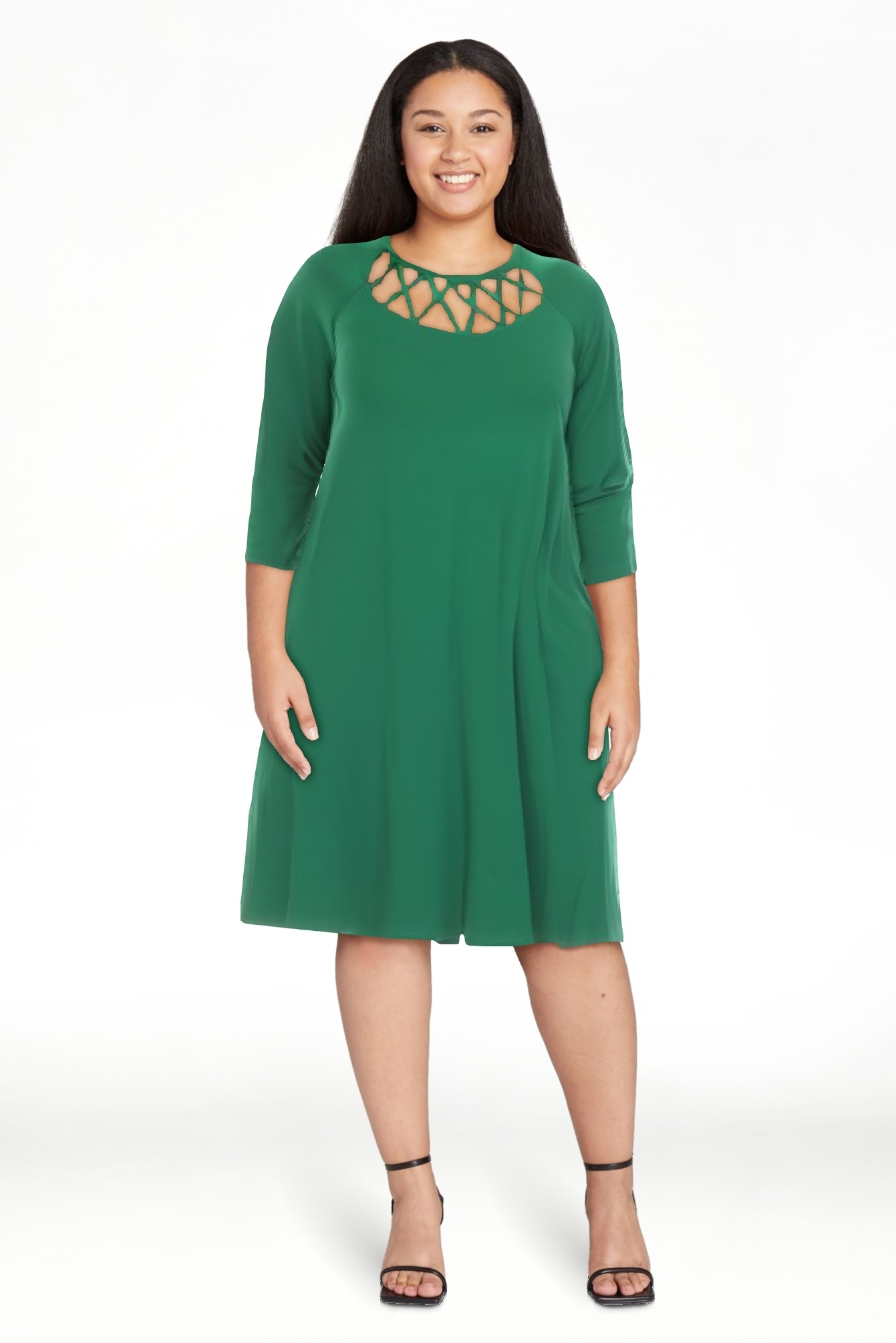 Model in a green dress with a crisscross neckline and three-quarter sleeves, smiling at the camera