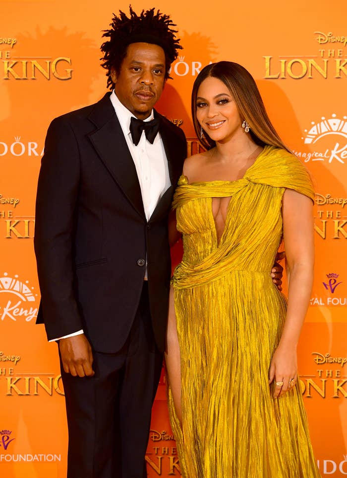 Jay-Z in a classic suit and Beyoncé in an elegant, one-shoulder draped gown pose together
