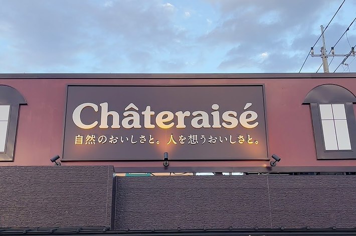 シャトレーゼの店舗看板、雲が少し見える空の下にある。