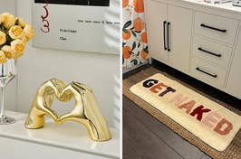 to the left: gold statue of hands making a heart-shape, to the right: a bath mat that says get naked