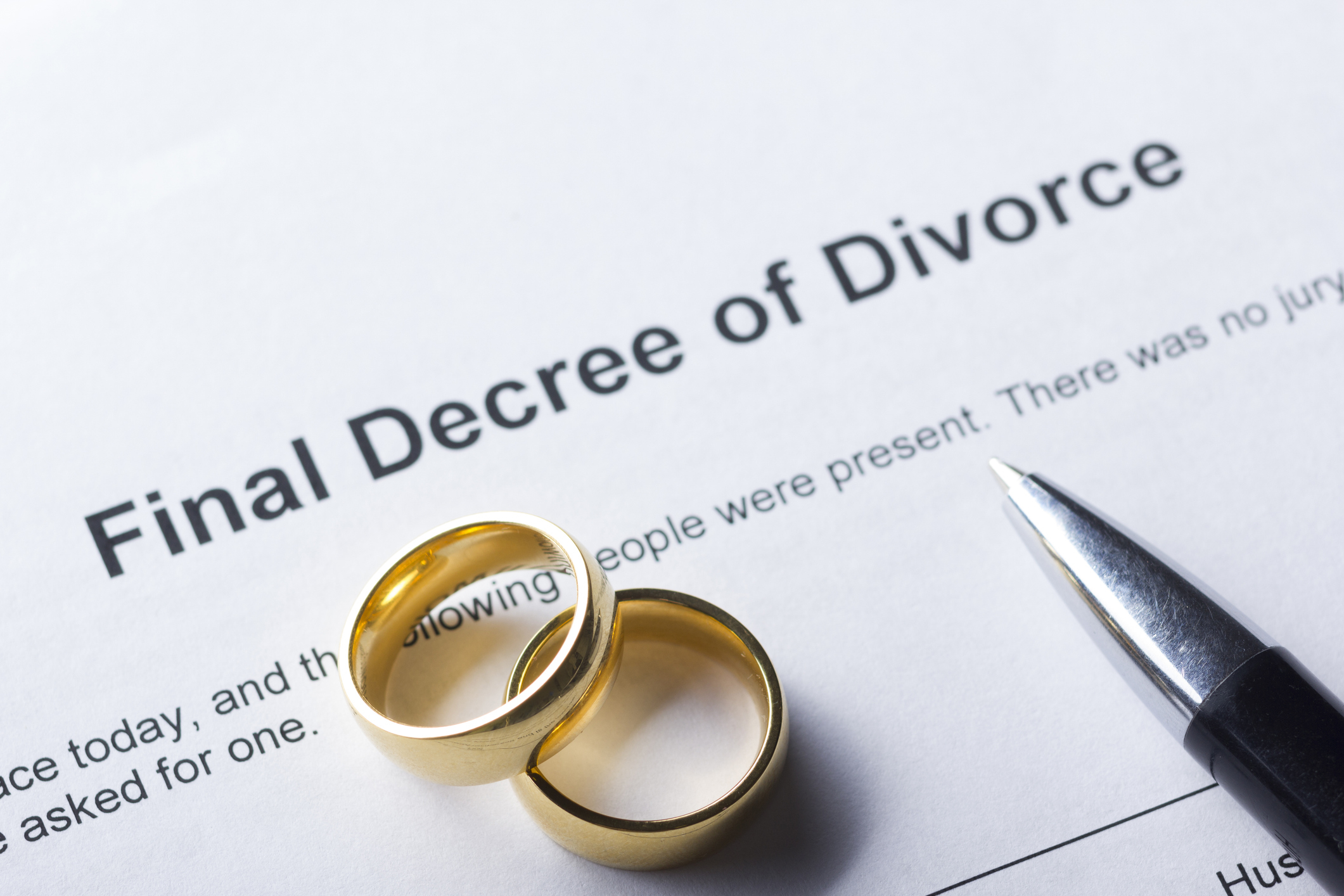 Document titled &quot;Final Decree of Divorce&quot; with two wedding rings and a pen, indicating the end of a marriage