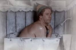 Man in a makeshift bath, looking pensive with makeshift headwear