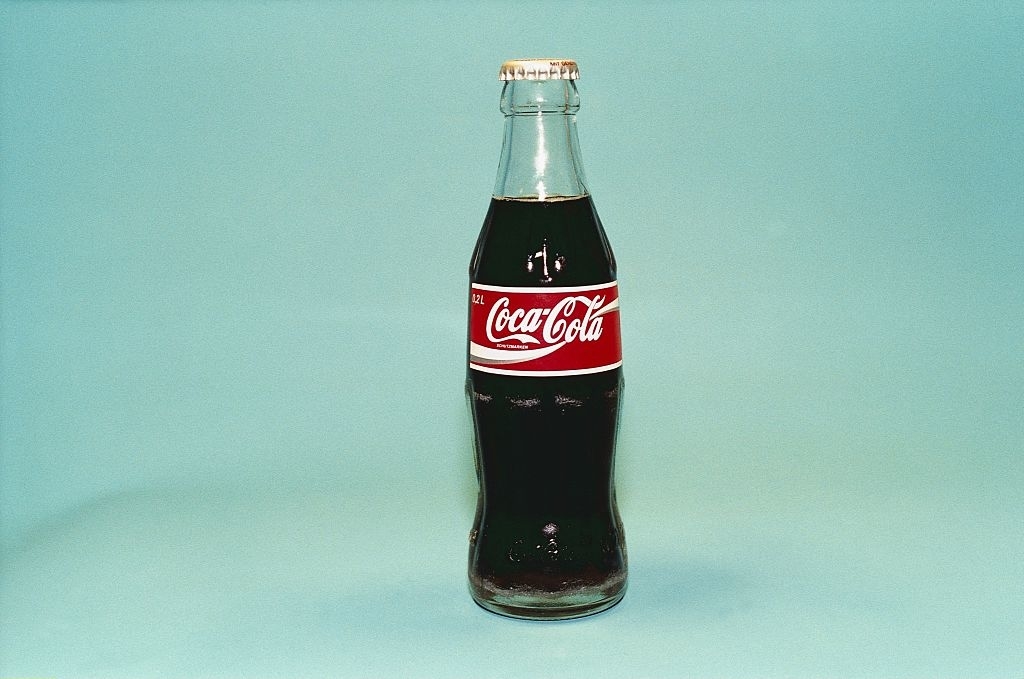Classic glass Coca-Cola bottle on a plain background
