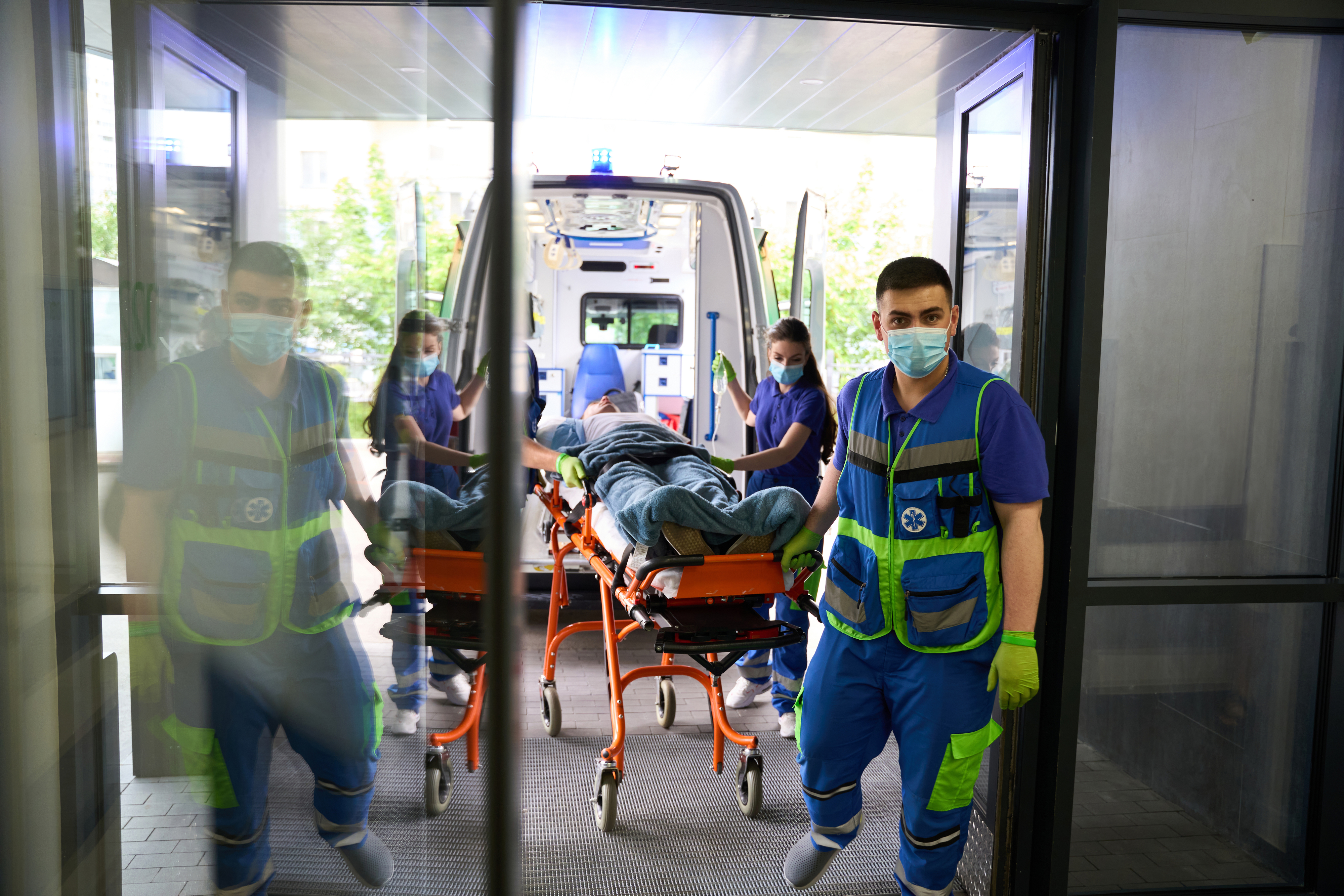 Paramedics wheeling a patient on a stretcher from an ambulance