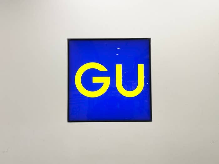壁にかかっている「GU」と書かれた青い看板。