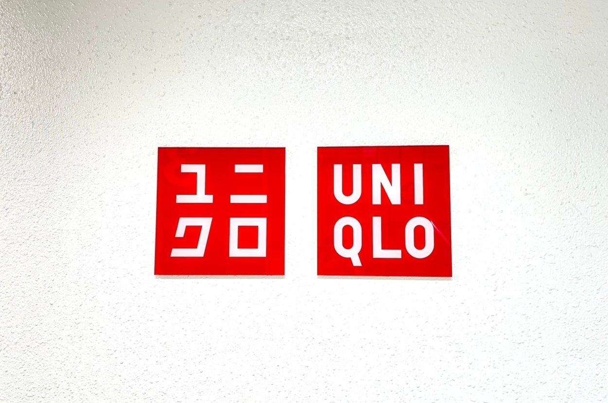 Signs for "UNIQLO" in both Japanese and English on a wall
