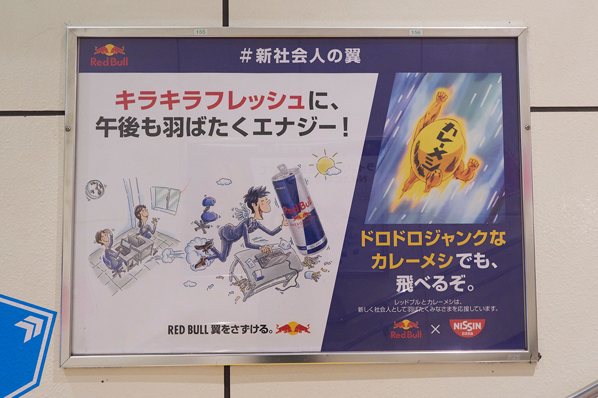 キャラクターイラストと商品写真がある広告看板です。左側にはエネルギードリンク、右側にはカップ麺のイラスト。