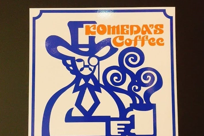 ロメダスコーヒーのロゴ、西部風のキャラクターがコーヒーカップを持つデザイン。