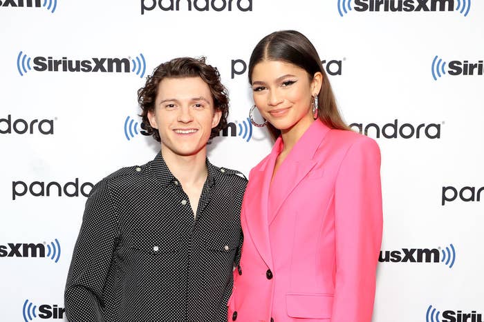 Closeup of Tom Holland and Zendaya smiling for photographers on the red carpet