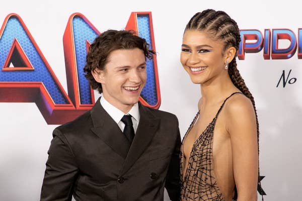 Tom Holland in a suit and Zendaya in a mesh dress smile at a &#x27;Spider-Man&#x27; event