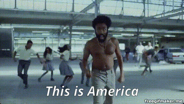 Person dancing among a crowd with the text &quot;This is America&quot; displayed