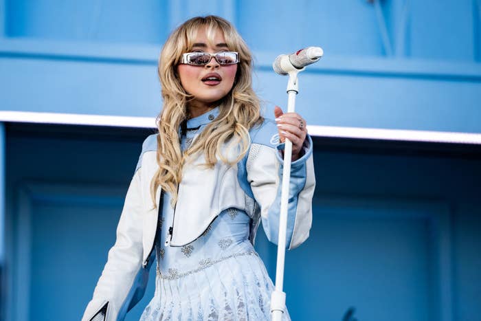Sabrina Carpenter onstage holding a mic stand
