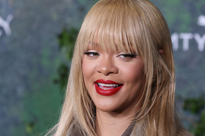 Woman with red lipstick and straight hair with bangs smiling