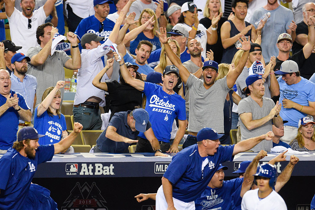 Excited crowd of baseball fans cheering at a game, some in Dodgers attire