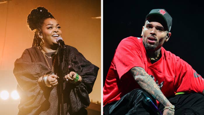 Two singers performing on stage, Jill Scott in a draped top and Chris Brown in a red sporty outfit