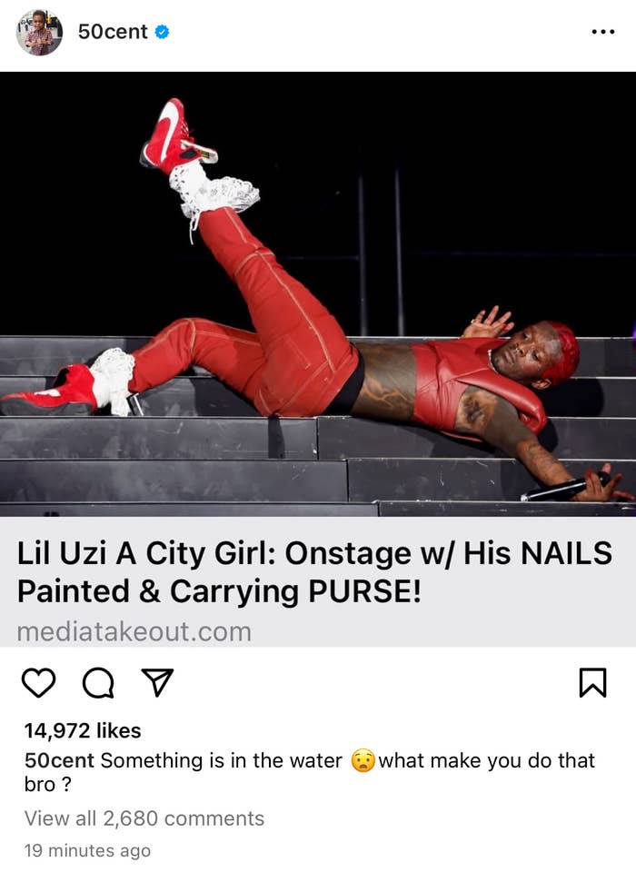 Lil Uzi Vert lies on stage mid-performance, wearing red, with painted nails and a purse