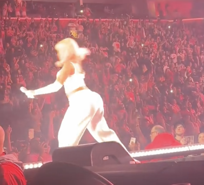 Nicki Minaj in a white outfit on stage with an audience in the background