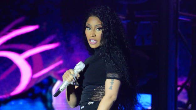Nicki Minaj wearing a black outfit, performing on stage with a microphone
