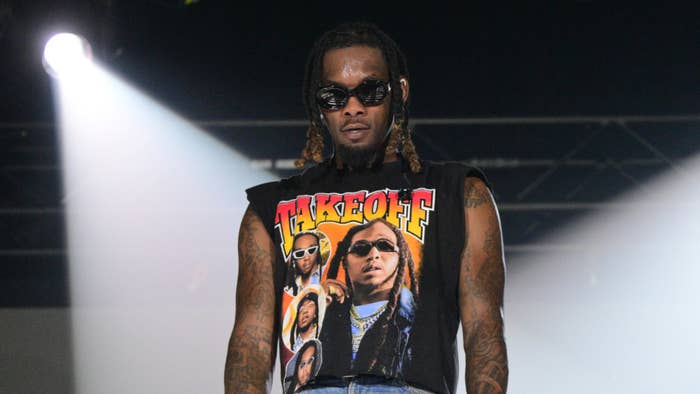 Offset on stage wearing a graphic tank top and sunglasses, with braided hair