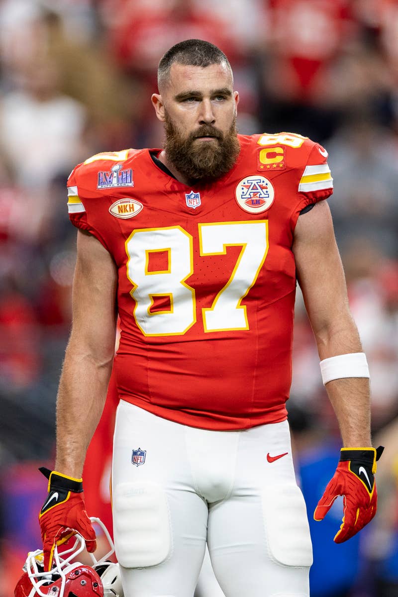 Travis Kelce in his Kansas City Chiefs #87 football uniform, helmet off, on the field