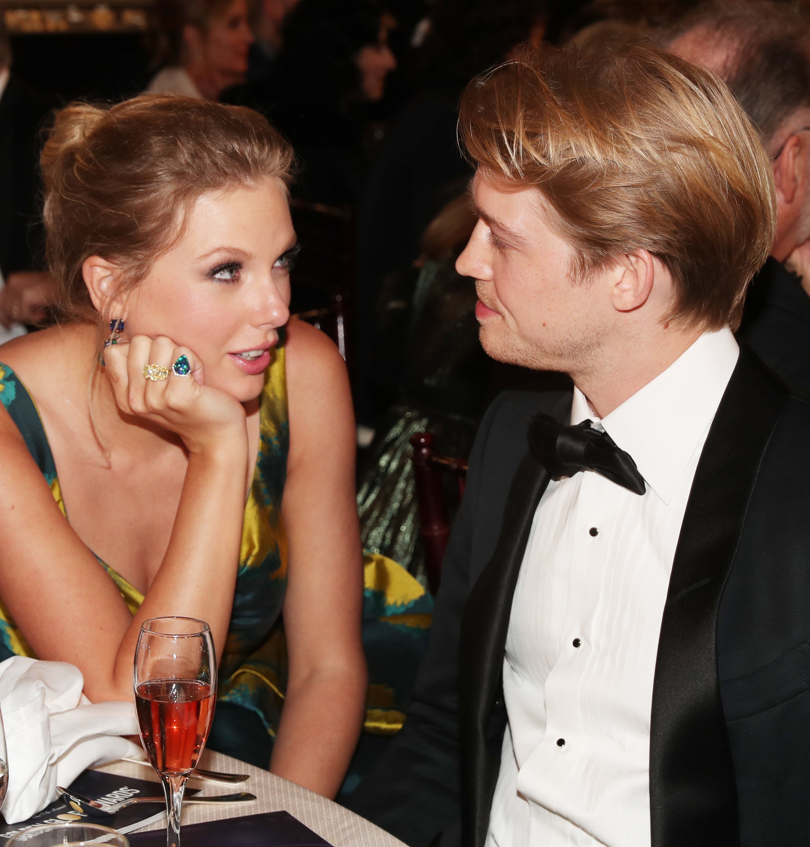 Closeup of Taylor Swift and Joe Alwyn sitting at a table at a media event