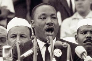 Martin Luther King Jr. speaking passionately into microphones at a podium