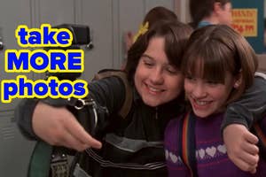 Two characters from a TV show smiling and taking a selfie with the text "take MORE photos" overlaying the image