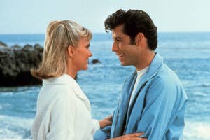 Sandy and Danny from Grease smiling at each other on the beach