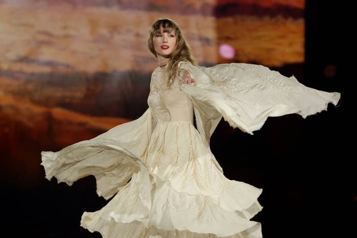 Taylor Swift in a flowing dress dancing and performing onstage