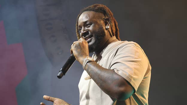T-Pain performing on stage with microphone in hand. He is wearing casual attire