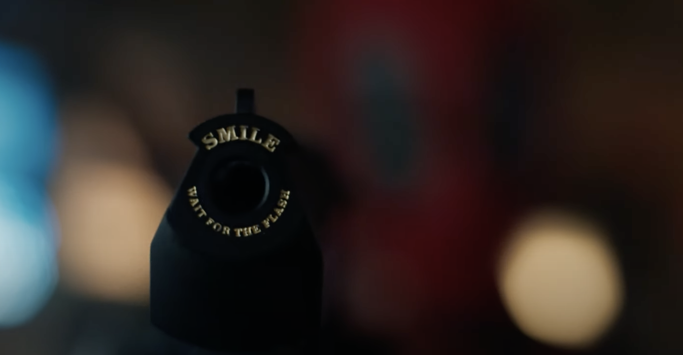 Close-up of a camera with the text &quot;SMILE WAIT FOR THE FLASH&quot; on a blurred background