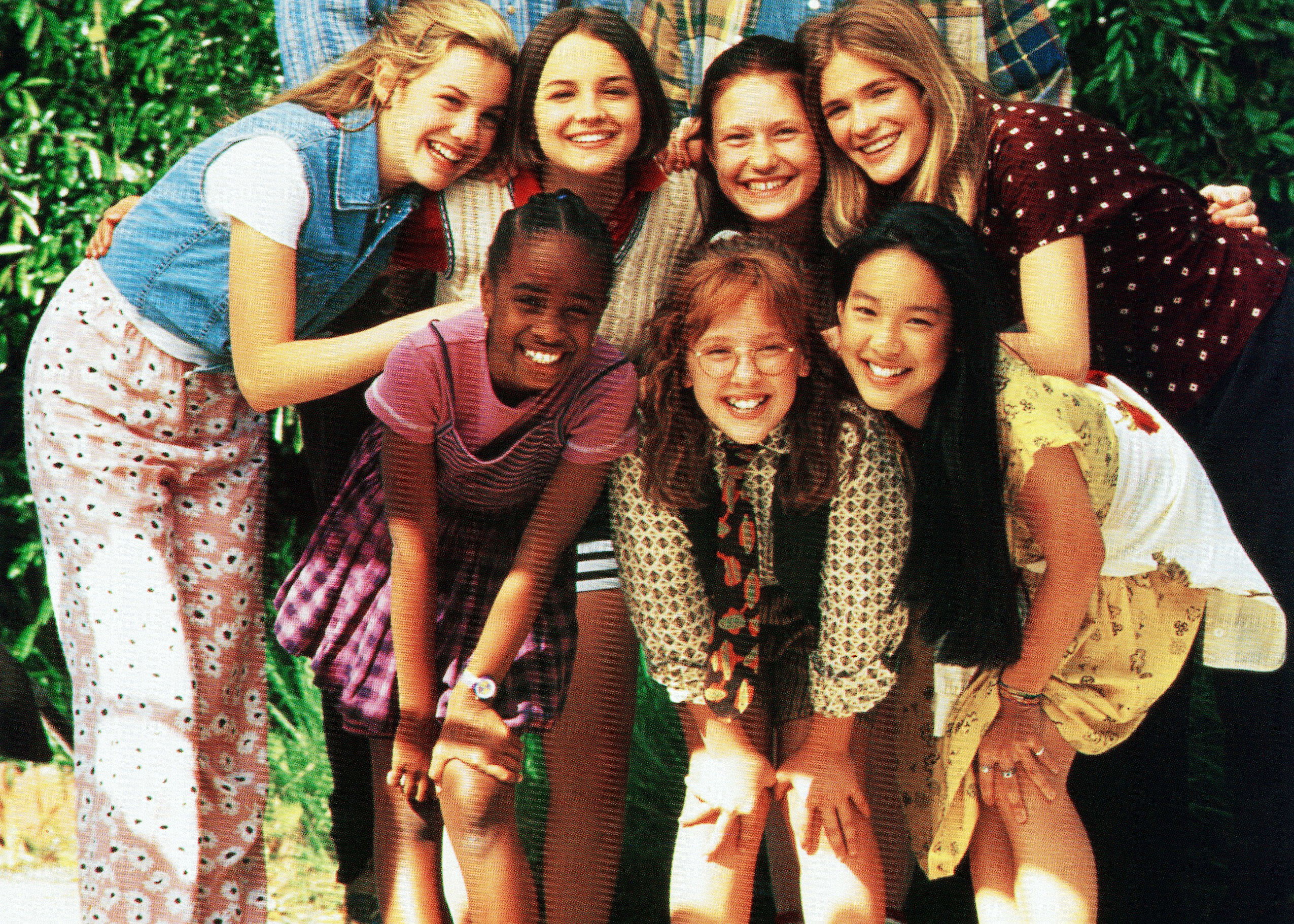 Group of seven young girls smiling and posing together