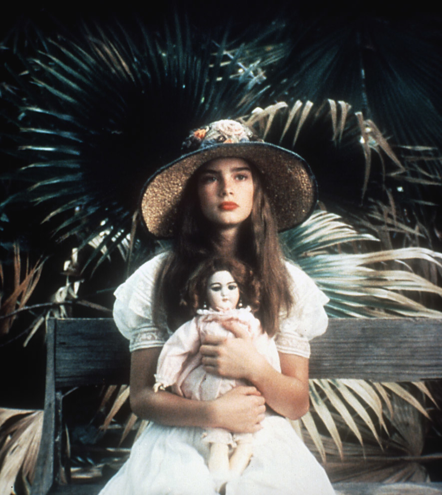 Brooke Shields in a scene from &quot;Pretty Baby,&quot; holding a doll, wearing a straw hat