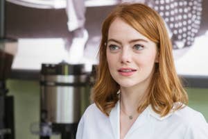 Emma Stone in white blouse in a cafe, looking away from the camera