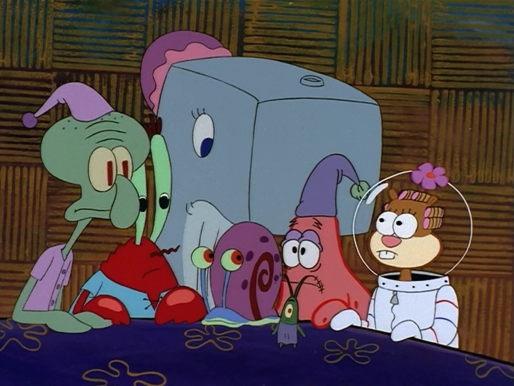 Squidward, Mr. Krabs, SpongeBob, and Sandy sitting at a table in SpongeBob SquarePants