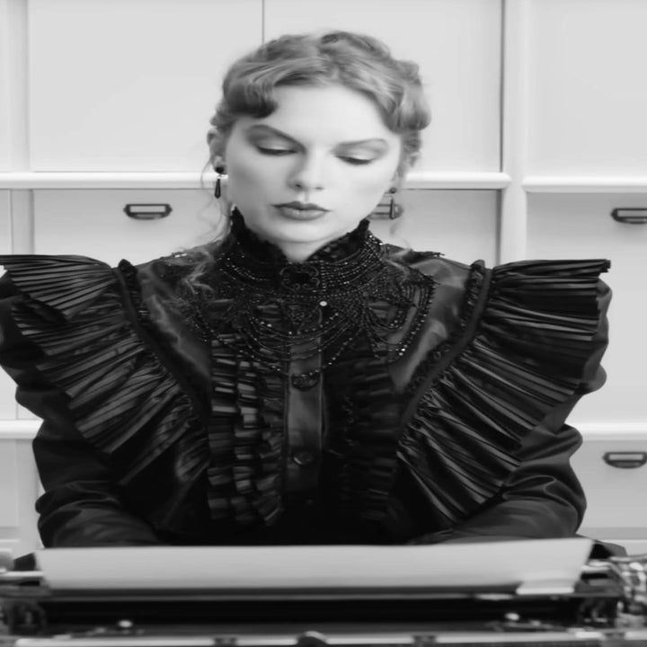 Taylor Swift wearing a ruffled top, seated at a typewriter in a stylized black and white setting